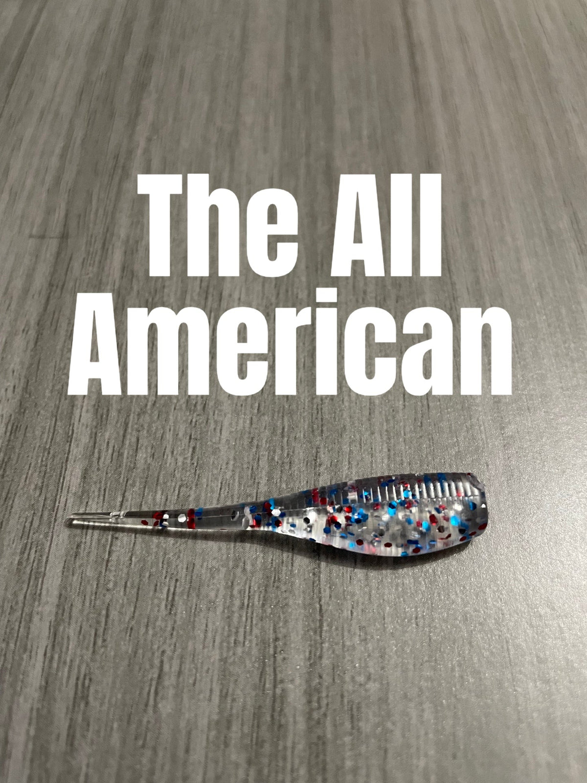 The All American Shad Body crappie bait featuring a clear body with red, white, and blue glitter.