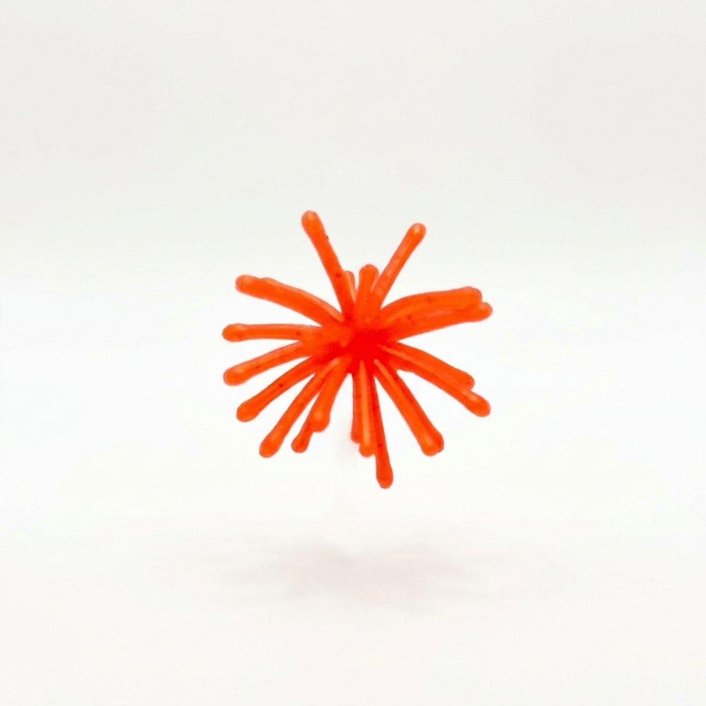 The Urchin crappie bait in bright orange with black flake, featuring a solid center and flexible tentacles.